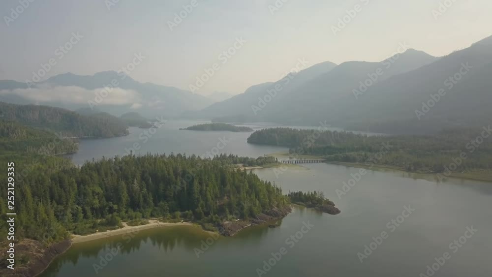 Aerial panoramic landscape view of Kennedy Lake during a cloudy summer day. Taken near Tofino and Ucluelet, Vancouver Island, BC, Canada. Aerial panoramic landscape view of Kennedy Lake during a cloudy summer day. Taken near Tofino and Ucluelet, Vancouver Island, BC, Canada.