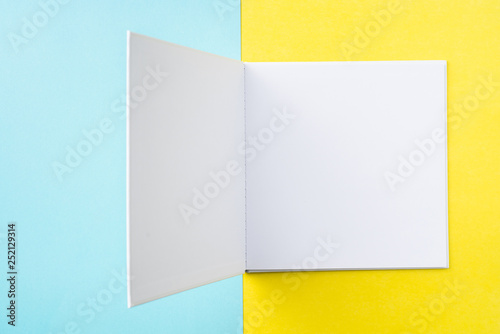 opened white square notebook on yellow and blue