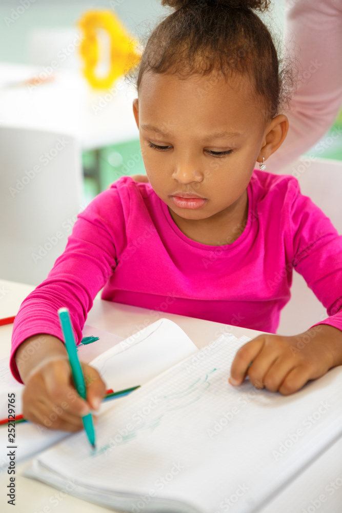 Beautiful little African American little girl on a drawing lesson at school Beautiful little African American little girl on a drawing lesson at school