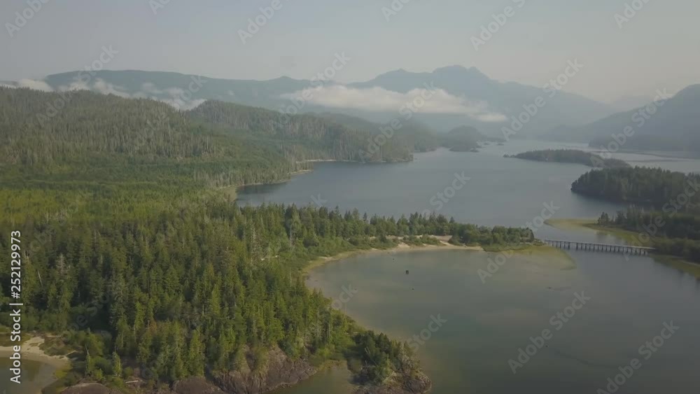 Aerial panoramic landscape view of Kennedy Lake during a cloudy summer day. Taken near Tofino and Ucluelet, Vancouver Island, BC, Canada. Aerial panoramic landscape view of Kennedy Lake during a cloudy summer day. Taken near Tofino and Ucluelet, Vancouver Island, BC, Canada.