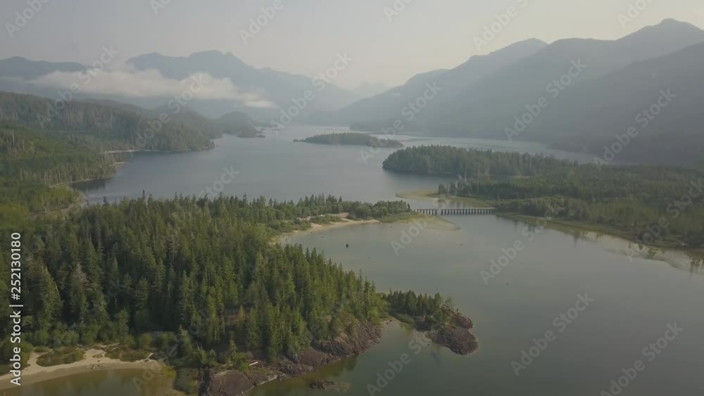 Aerial panoramic landscape view of Kennedy Lake during a cloudy summer day. Taken near Tofino and Ucluelet, Vancouver Island, BC, Canada. Aerial panoramic landscape view of Kennedy Lake during a cloudy summer day. Taken near Tofino and Ucluelet, Vancouver Island, BC, Canada.