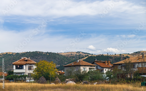 Typical natural rural landscape in Bulgaria, village with red roofs, hills on the horizon