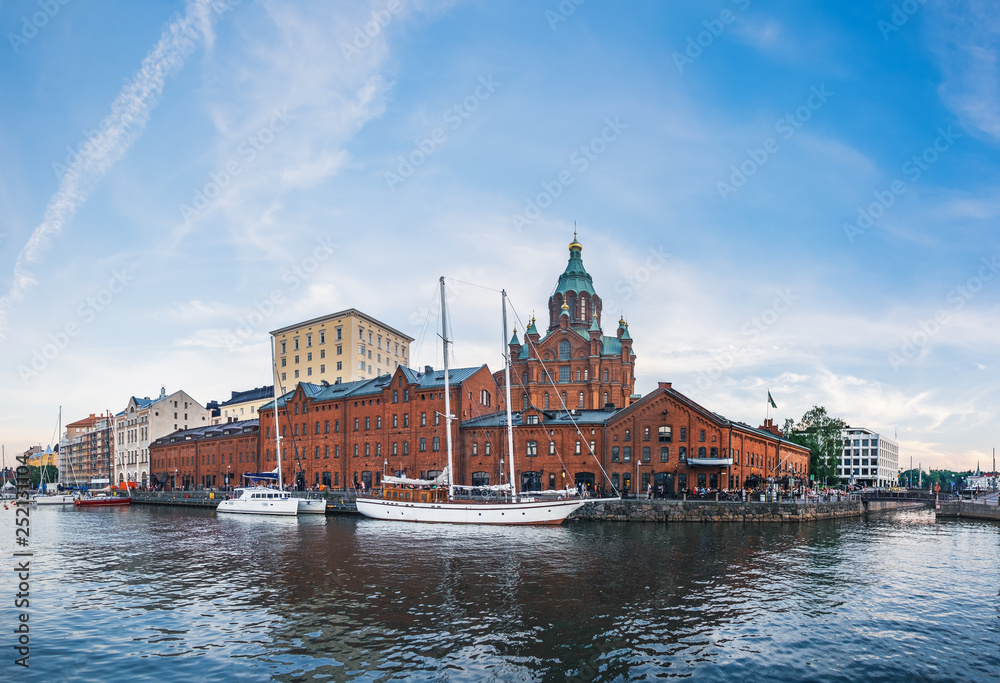 Town pier of Helsinki with old boats and sailing ship on summer evening, Finland. Town Quay and Uspenski Orthodox Cathedral Church in Katajanokka district, famous tourist destination