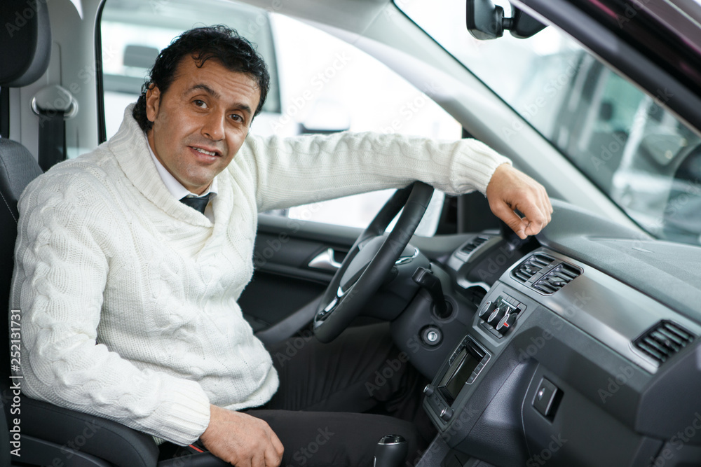 Mature man choosing a new car at the dealership salon Mature man choosing a new car at the dealership salon