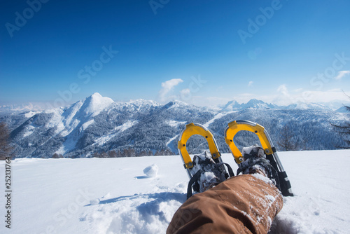 Austria, Salzburg State, Altenmarkt-Zauchensee, man with snowshoes lying in deep snow photo