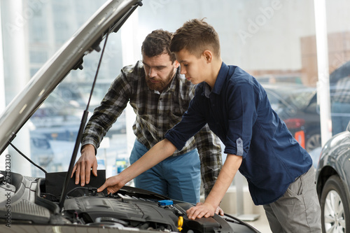 Handsome mature man and his young son buying a new automobile together