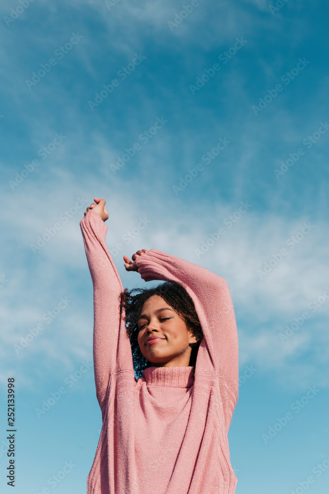 Portrait of smiling young woman wearing pink pullover against sky Portrait of smiling young woman wearing pink pullover against sky