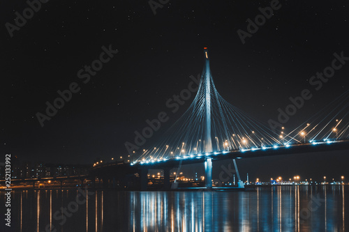 Beautiful cable-stayed bridge in St. Petersburg, Russia, with starry sky and cozy city lights