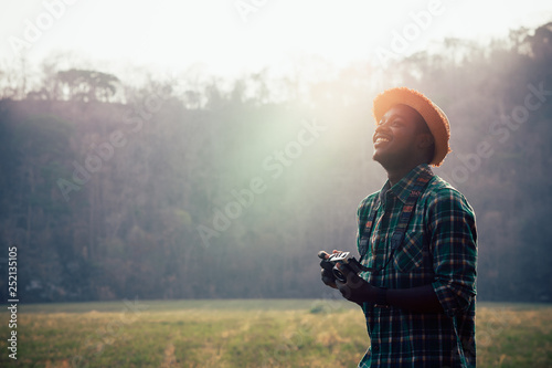 African man traveller holding film camera on a green meadow photo