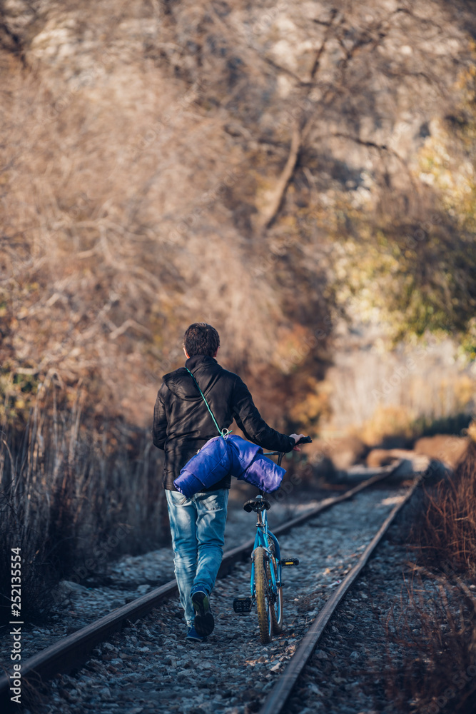 Boy walking on the train track with bicycle Boy walking on the train track with bicycle