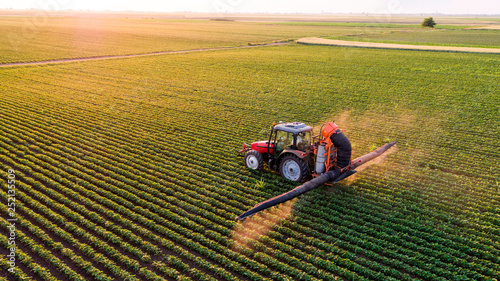 Serbia, Vojvodina, Aerial view of a tractor spraying soybean crops