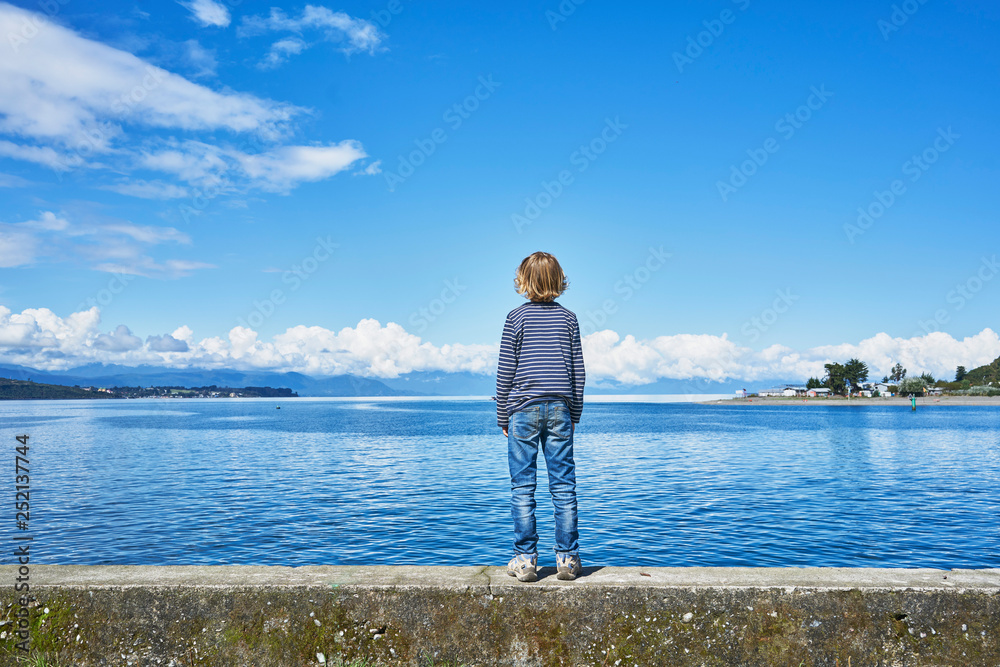 Chile, Puerto Montt, boy standing on quay wall at the harbor Chile, Puerto Montt, boy standing on quay wall at the harbor