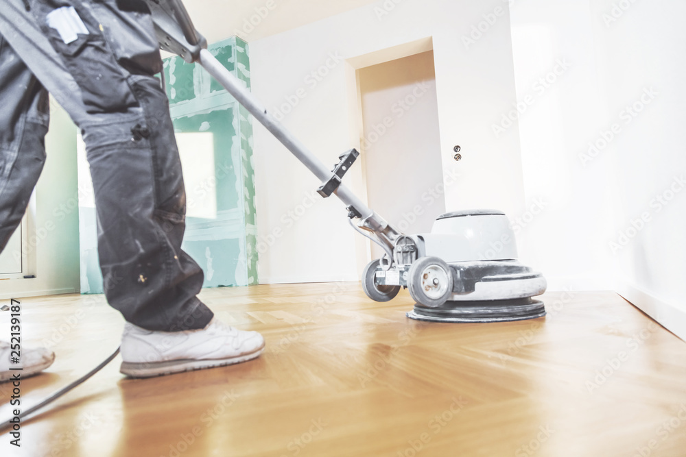 Fototapeta premium Varnishing of oak parquet floor, workers tool.