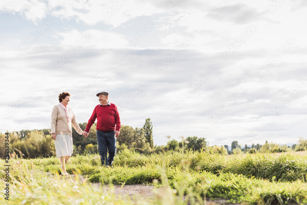 Senior couple on a walk in rural landscape Senior couple on a walk in rural landscape