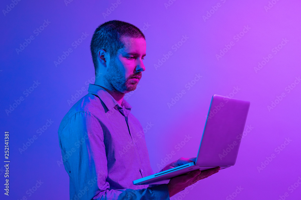 Businessman typing on a handheld laptop computer Businessman typing on a handheld laptop computer