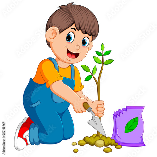 A boy planting a green young plant with fertilizer
