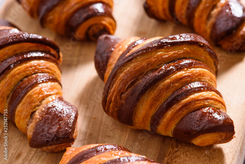 fresh homemade croissants with chocolate on wood surface photo