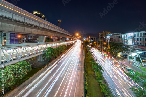 traffic light and sky train system in rush hour at twilight time in Bangkok, transportation with cityscape concept