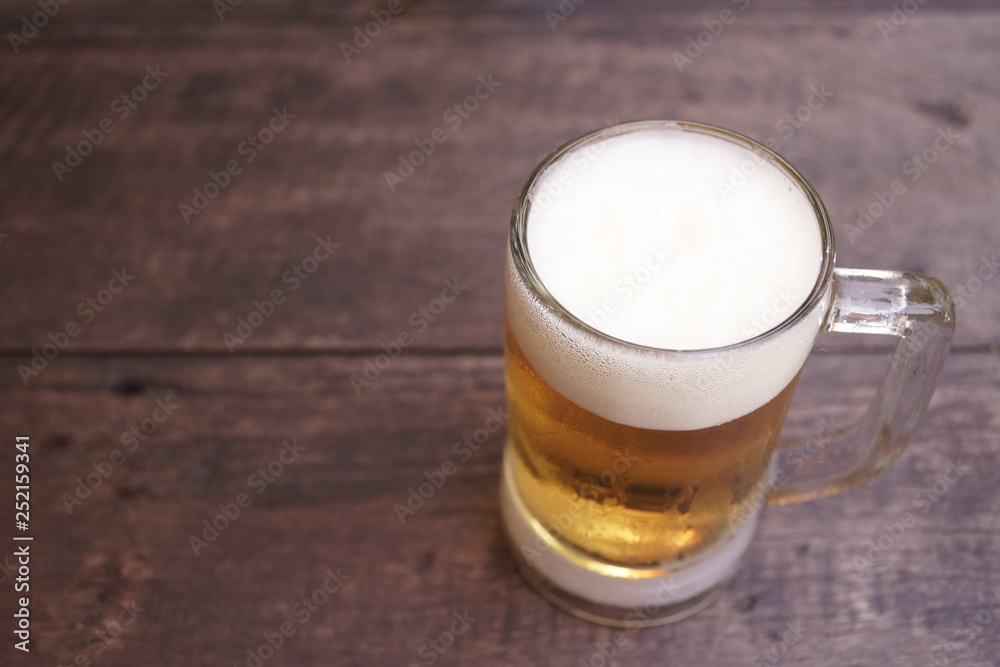 Glass of light beer on the wooden table Glass of light beer on the wooden table