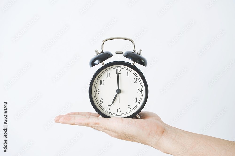 Hand holding alarm clock on white background. Hand holding alarm clock on white background.