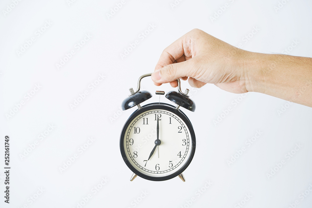 Hand holding alarm clock on white background. Hand holding alarm clock on white background.