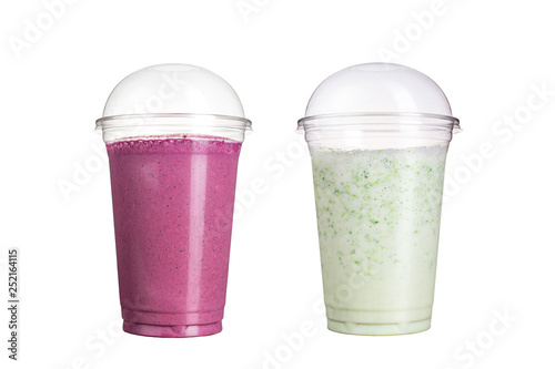 Delicious fruit smoothies in plastic cups, on a white background. Two cocktails with the taste of wild berries and milk.