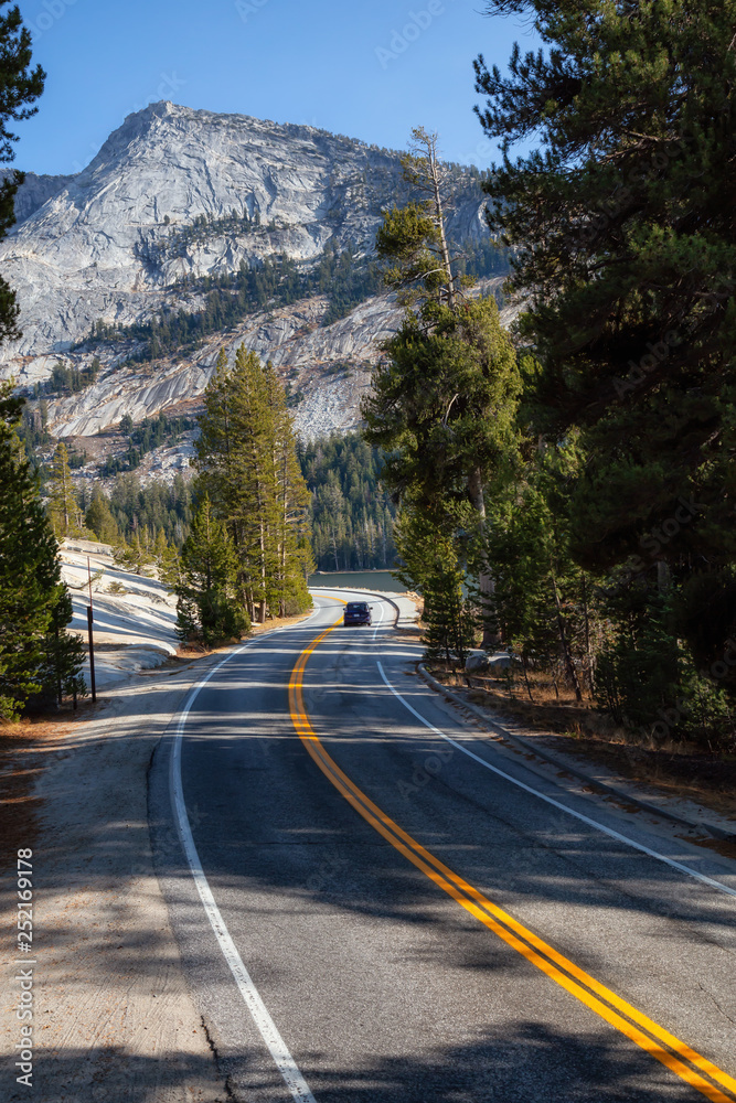 View of a scenic road, Tioga Pass, in the Valley surrounded by mountains. Taken in Yosemite National Park, California, United States.