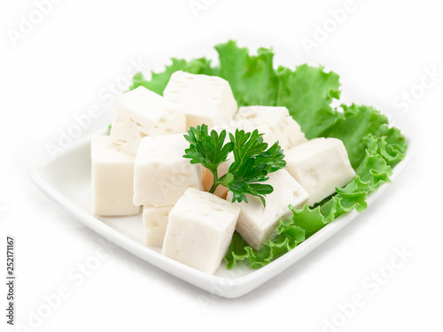 Cheese cubes on a plate with lettuce leaves