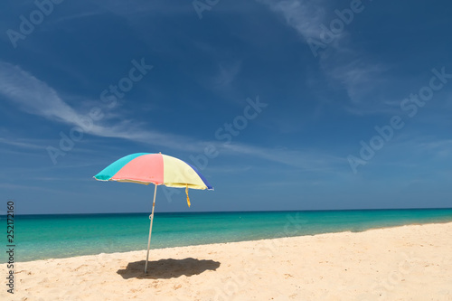 Raise an beach umbrella on beautiful sunny day, clear sea and sky on background