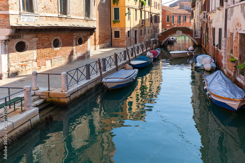 View of the narrow side of the canal, moored boats, Venice, Italy