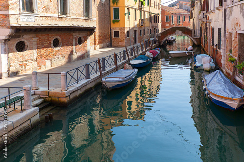 View of the narrow side of the canal  moored boats  Venice  Italy