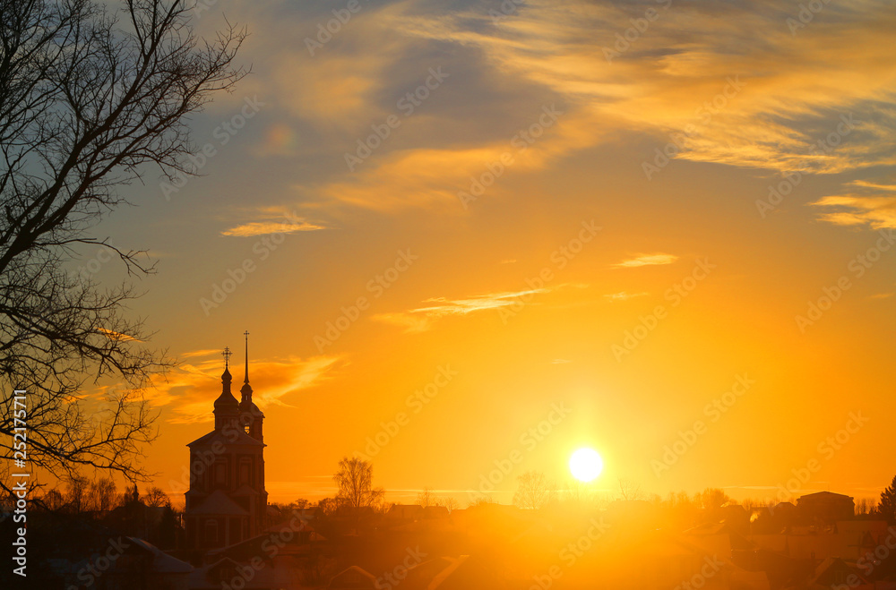 Bright photo the sunset in the winter with the Church in Russia