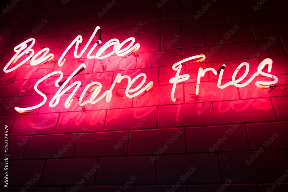 Red neon sign in the cafe on black background.
