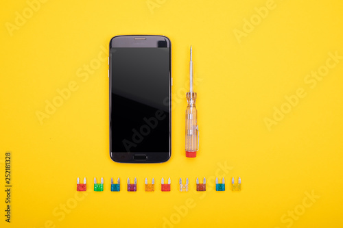 Set of electrical tool with black smartphone on colorful background photo