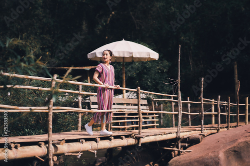 portrait of asian women in lanna uniform from thailand north in outdoor mountain and nature with concept relaxing in travel and vacation by standing on bamboo bridge