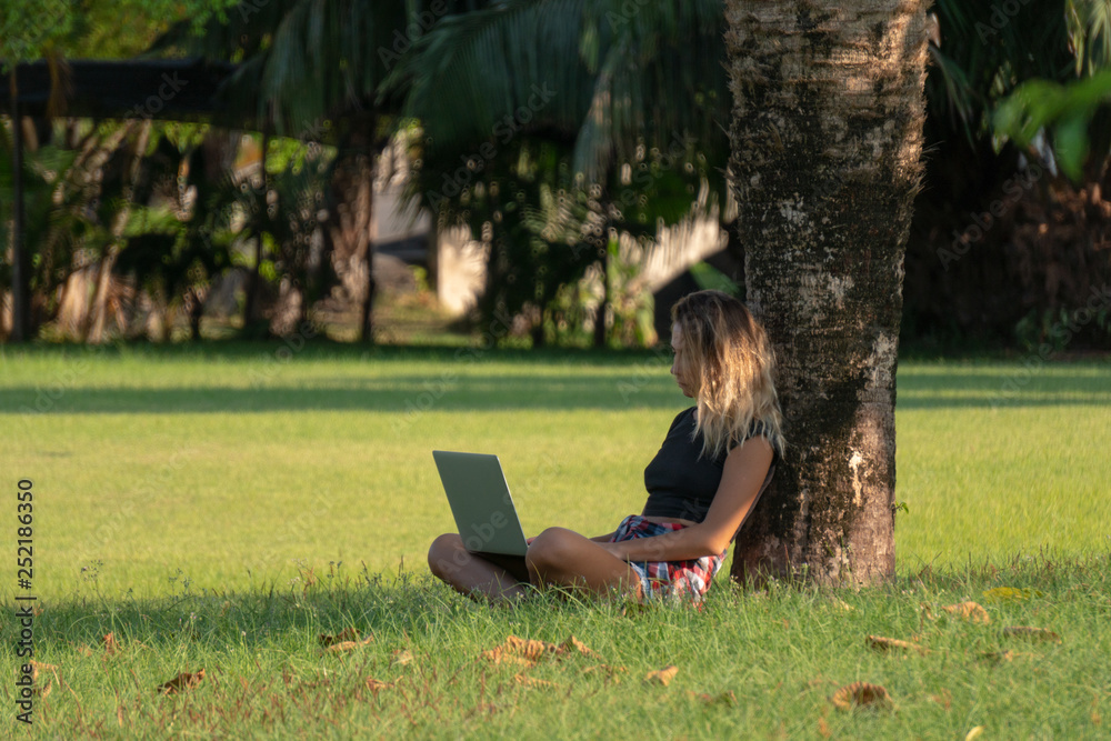 young student sitting under tree in summer park, girl is preparing for seminar, young student sitting under tree in summer park, girl is preparing for seminar,