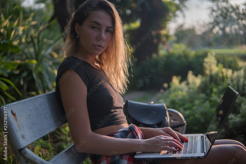 Portrait of a young woman on a park bench, a girl has a laptop on her knees, Portrait of a young woman on a park bench, a girl has a laptop on her knees,