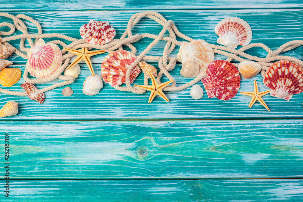 Naklejka premium Different sea shells on color wooden background