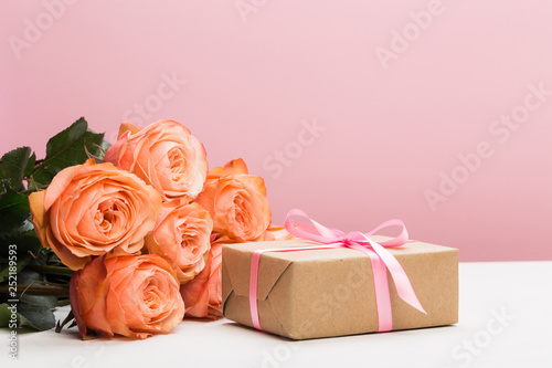 rose roses with present on pink background, mother's day, woman's day