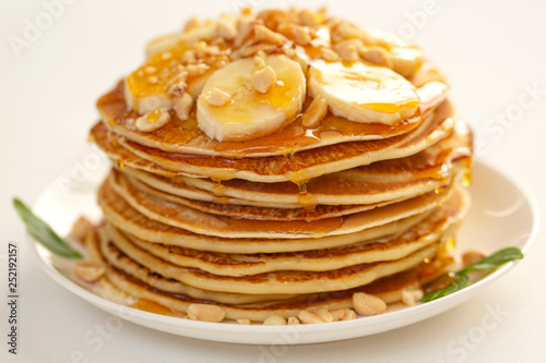 Sweet Homemade Stack of Pancakes with banana, nuts and honey. Delicious breakfast.