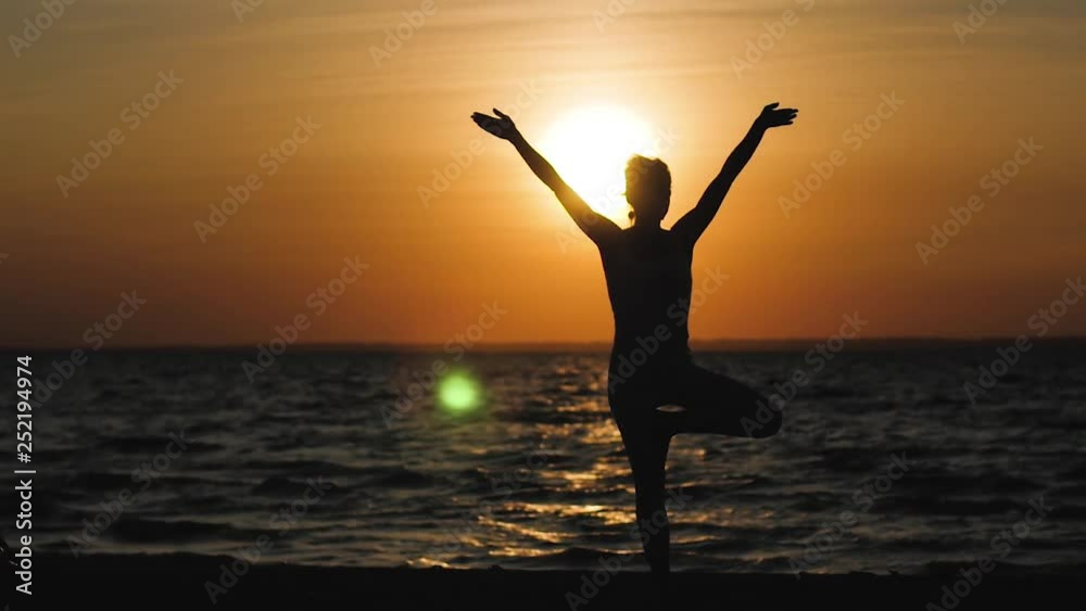 woman doing yoga on the beach on the background of the water and the sunset, silhouette. kundalini yoga woman doing yoga on the beach on the background of the water and the sunset, silhouette. kundalini yoga