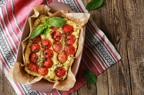 Baking dish with tasty Italian focaccia on wooden table