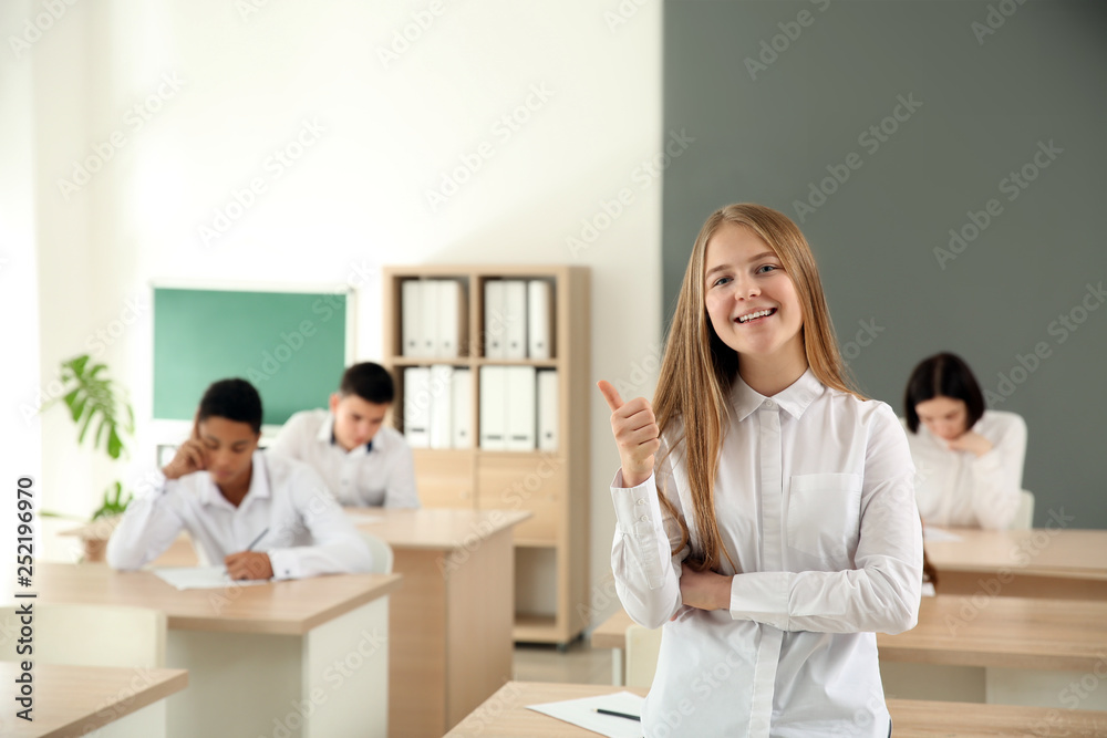Happy girl after passing school test in classroom Happy girl after passing school test in classroom
