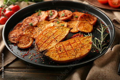 Plate with tasty baked sweet potato on table