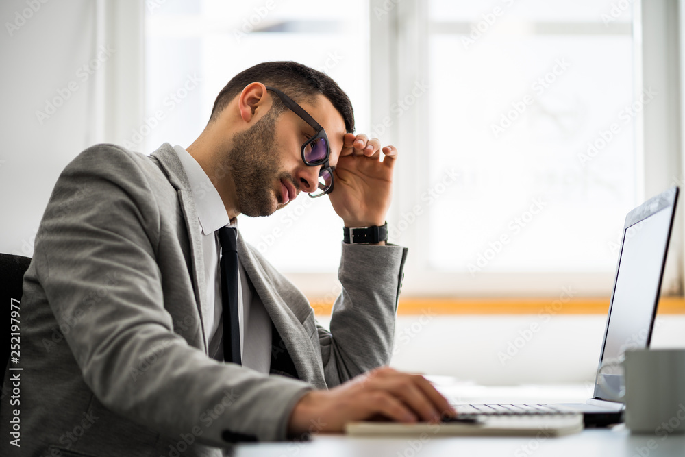 Young businessman is working in office. He is worried. Young businessman is working in office. He is worried.