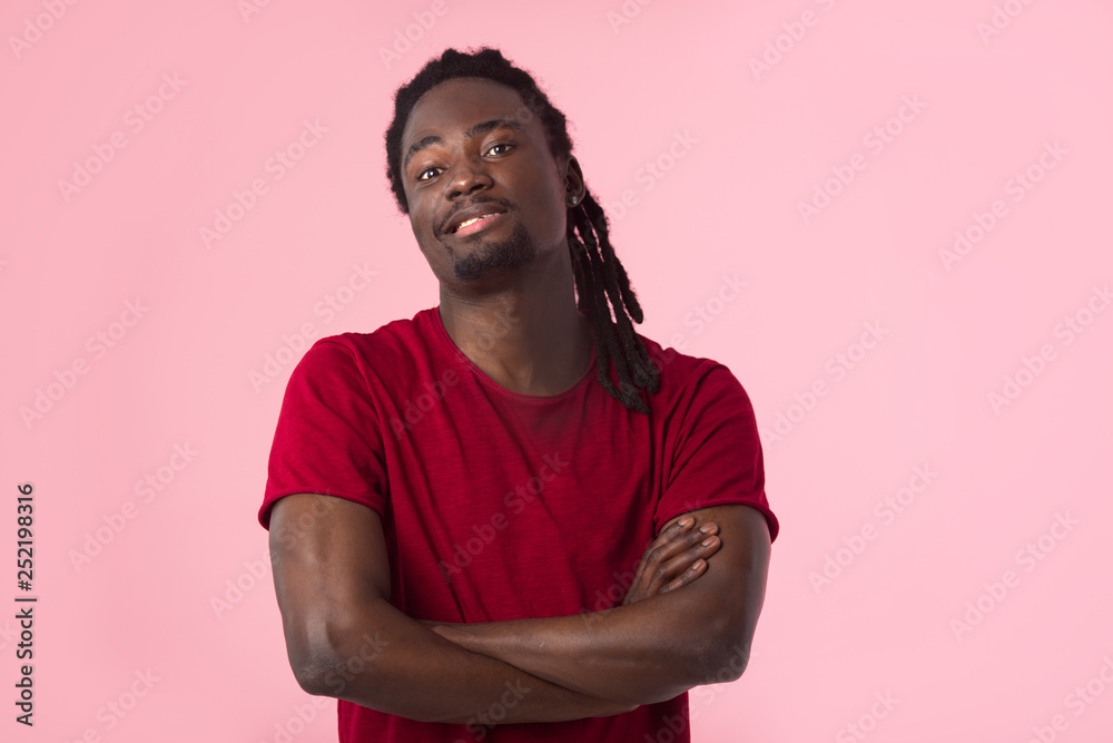 Obraz premium handsome african man with dreadlocks in a red t-shirt on a pink background