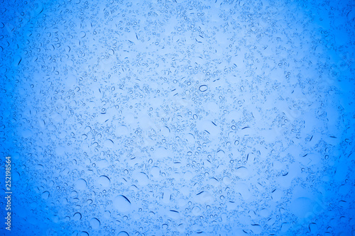 Rain droplets on blue glass background, Water drops on blue glass.