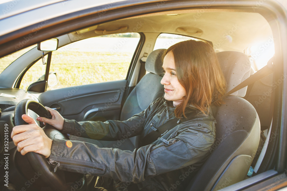 pretty young smiling woman driving a car, sunny weather pretty young smiling woman driving a car, sunny weather