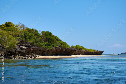 View of coastline with beach. Sea or ocean with boat and blue sky. Kenya