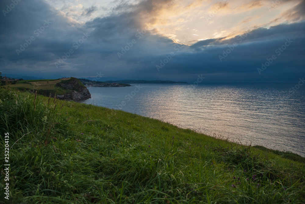 Green landscape of marine coast with cloudy sunset Green landscape of marine coast with cloudy sunset